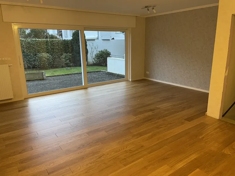 Wohnraum mit dunkler Landhausdiele und Terrassentür